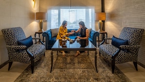 A room with a sofa, two armchairs, a glass coffee table, and two lamps. - Ambassador Hotel Amman, a Boutique Hotel (Amman)