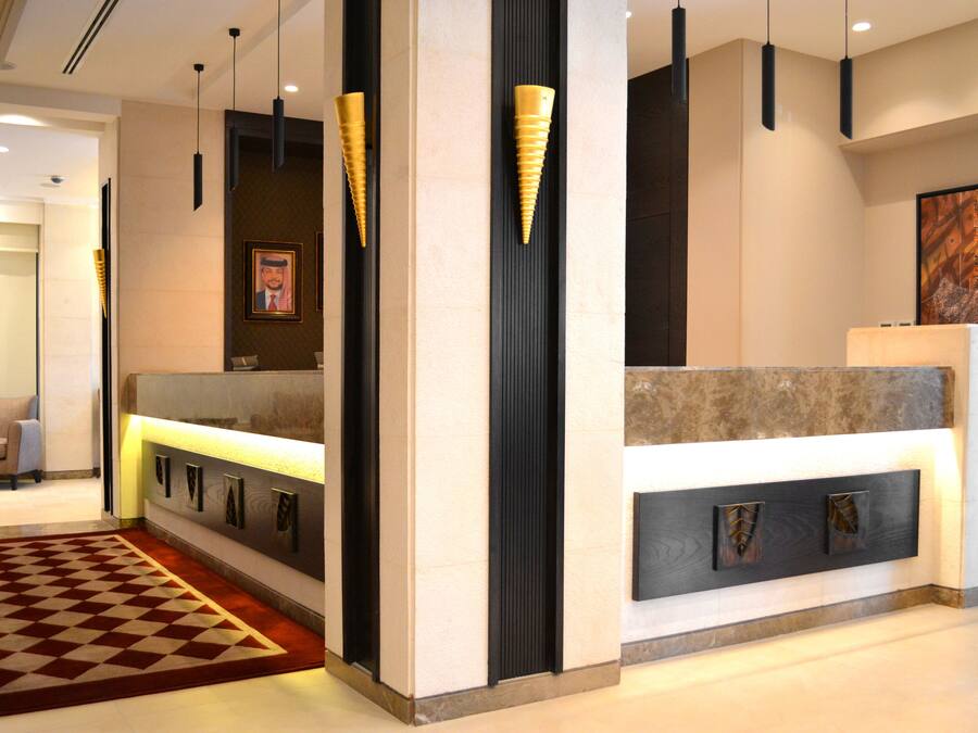 A reception area with a check-in counter, a framed portrait, and a patterned carpet.