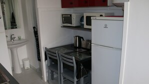 A compact kitchen with a sink, a microwave, a toaster, and a refrigerator.