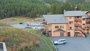 A multi-story building with a parking area and a road leading to it. - Cozy 2-Bed Apartment with Balcony, 100m from Slopes and Shops in Vars Les Claux (Vars)