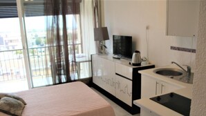 Une chambre avec un lit, une télévision, une machine à café et un lavabo.