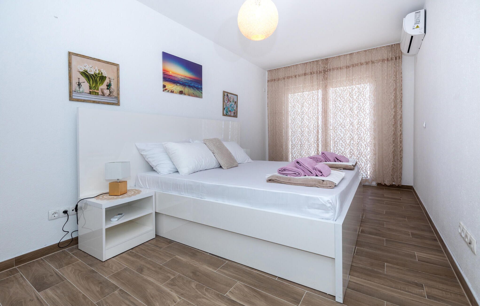 A bedroom with a bed, bedside table, and a shelf unit.