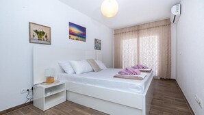Une chambre à coucher avec un lit, une table de chevet et une étagère.