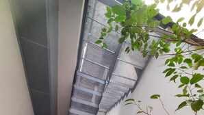 A modern staircase with metal railings and a glass door at the bottom. - 2 balconies! Lovely Center Apartments Alfalfa (Sevilla)