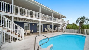 A two-story building with a swimming pool, outdoor seating, and a staircase. - Blue Lagoon - Lakefront Getaway Private Pool, One Block to the Beach, Sleeps 12 (Panama City Beach)
