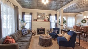 A spacious living room with a fireplace, comfortable seating, and a dining area. - 5th St Bungalow - Historic Charm Near 3rd St (McMinnville)