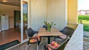 Un coin repas avec une table et des chaises, un réfrigérateur et une vue sur l’extérieur.