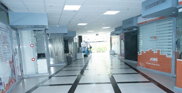 A corridor with glass doors, a tiled floor, and a 'JOBS' advertisement on the right.