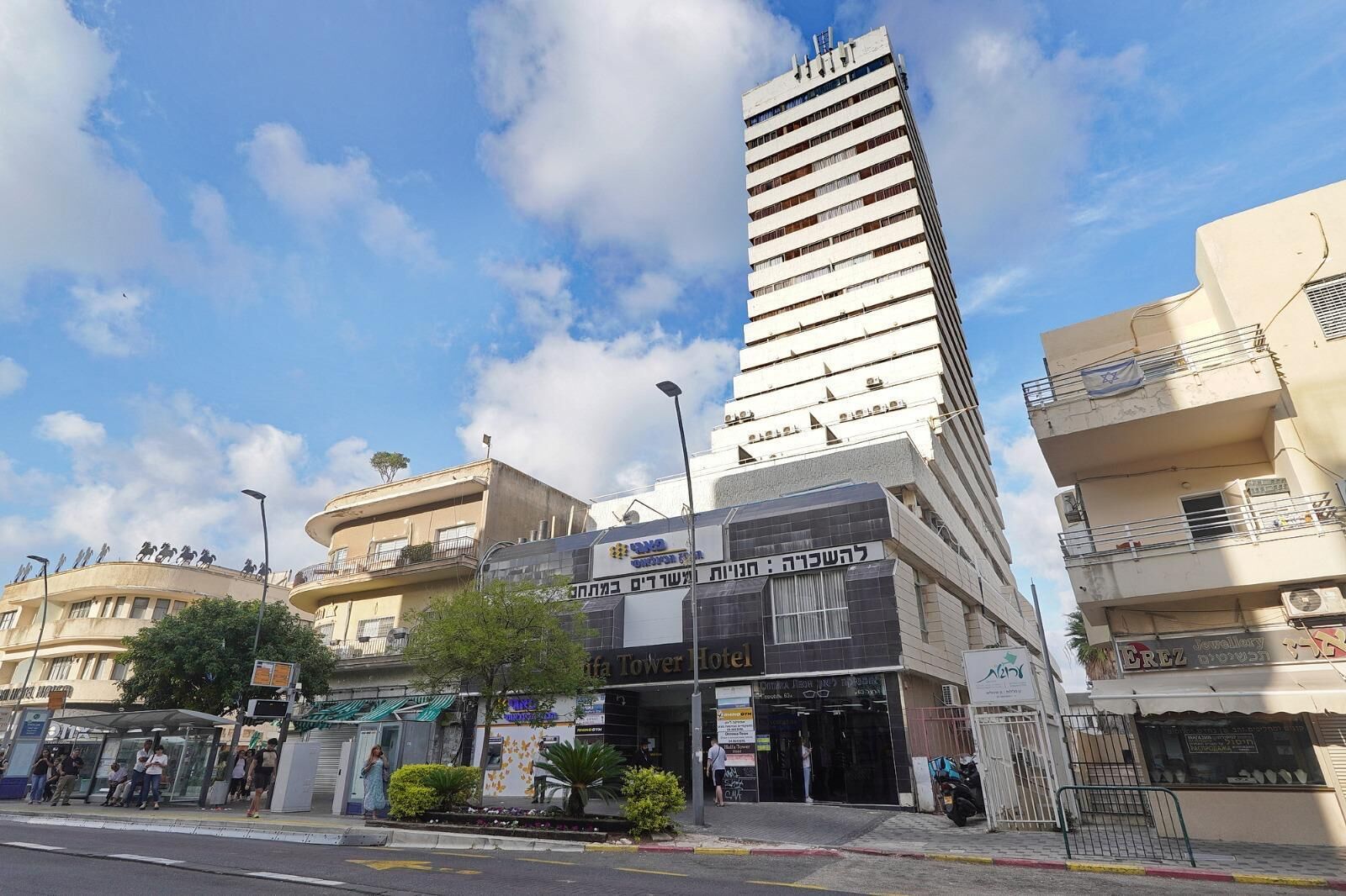 Um hotel com design moderno, apresentando uma imponente estrutura em torre e entrada no nível da rua.