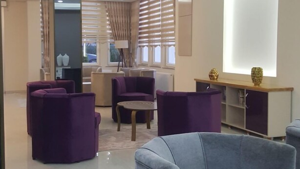 A modern lounge area with seating, a large window, and a ceiling with recessed lighting. - Engin Hotel (Gallipoli)