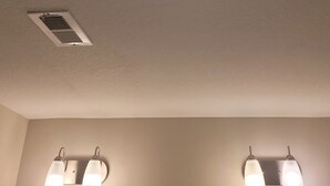 Et loft med en indbygget lysarmatur og en ventilationsgitter.