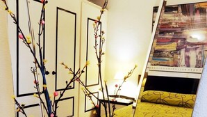 A room with a bed, a mirror, and a vase with branches. - Beautiful Apartment, Swimming Pool and Beach 2 (Platja d'Aro)