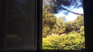 A window with a view of a forested area and a clear sky. - Beautiful Apartment, Swimming Pool and Beach 2 (Platja d'Aro)