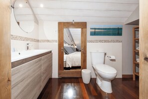 Een badkamer met een houten wastafel, toilet en spiegel.