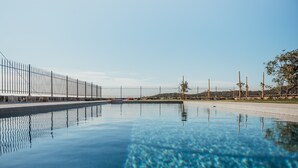 Una piscina limpia con una cerca de metal y un camino de hormigón.