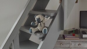 Eine Treppe mit einem Teddybären auf der Setzebene.