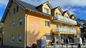Un bâtiment jaune avec une enseigne indiquant « Zur Linde Pension ».