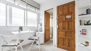 A modern room with a desk, chair, and bookshelf. - Minimalist Studio 3 Minutes Walk to Las Canteras Beach (Las Palmas de Gran Canaria)