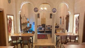 A dining area with checkered chairs, a chandelier, and a central rug. - Zuwinasa House Hotel (Avanos)