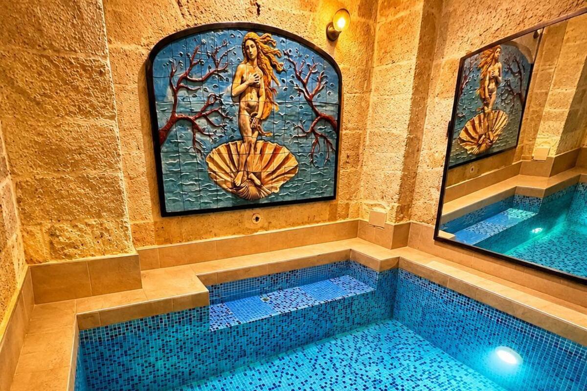 Una piscina con mosaicos y una estatua de una sirena.