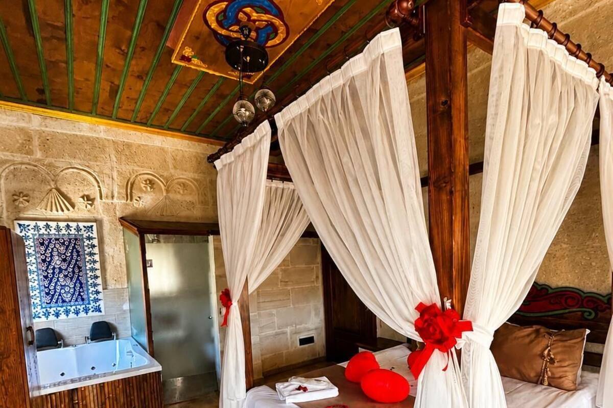Una habitación con cama con dosel, bañera y techo decorativo.