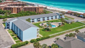 A hotel with a swimming pool, located near a beach with a view of the ocean. - Tradewinds 14 - Updated Gulf-View Condo, Community Pool, Beach Service Included! (Miramar Beach)