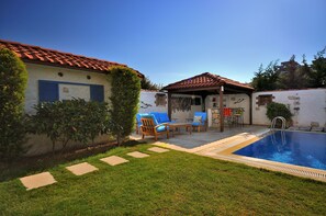 A poolside area with a tiled roof, a small covered seating area, and a pool. - Cesme Elysium Hotel (Cesme)