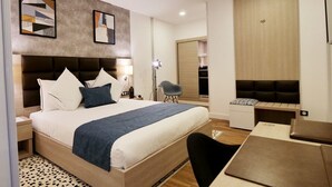 Une chambre d’hôtel moderne dotée d’un grand lit, d’un bureau et d’un coin salon.