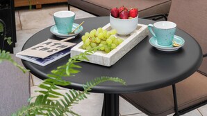 A spa area with a hot tub, a table with fruit and drinks, and a sofa with towels. - Kinglin Luxury Living (Athens)