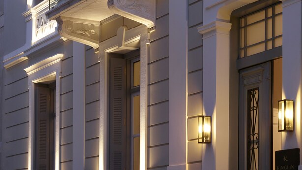 A building with classical architecture, featuring a balcony with glass railings and a decorative entrance. - Kinglin Luxury Living (Athens)