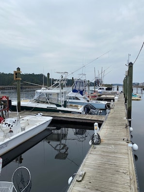 Un port de plaisance avec des bateaux amarrés, une jetée en bois et un panneau indiquant qu'il est interdit de fumer.