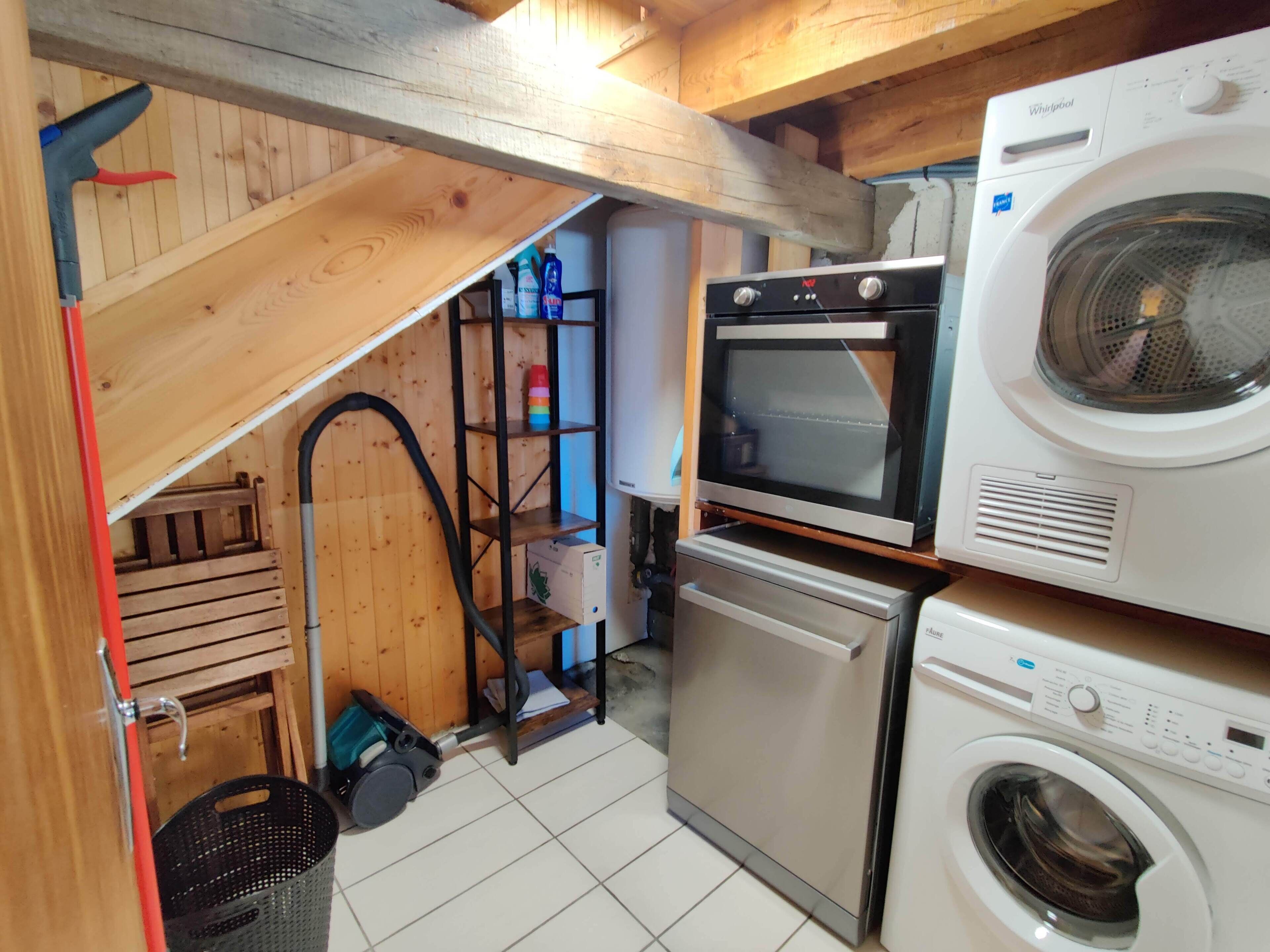 Een kleine keuken met een ingebouwde oven, magnetron en wasmachine.