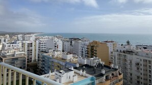 A coastal cityscape with modern buildings, a clear sky, and a view of the sea. - Armação Pêra magnificent sea view 100m from the beach (Armação de Pêra)