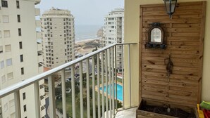A balcony with a view of a beach and high-rise buildings. - Armação Pêra magnificent sea view 100m from the beach (Armação de Pêra)