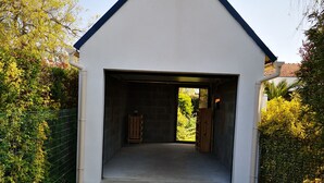 A building with a sloped roof and a gravel driveway leading to a covered entrance.