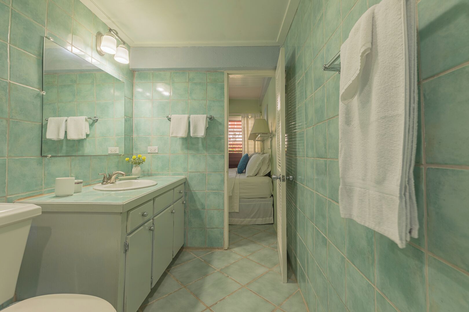 Een badkamer met een wastafel, spiegel en toilet.