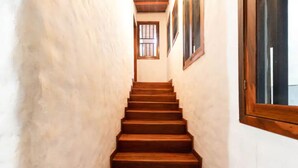 Eine Holztreppe führt zu einer Tür mit einem Fenster.
