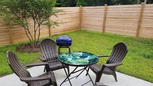 A patio with a round table and four Adirondack chairs. - SC (3745) 2BDR Townhouse Ft Jackson.   (Columbia)