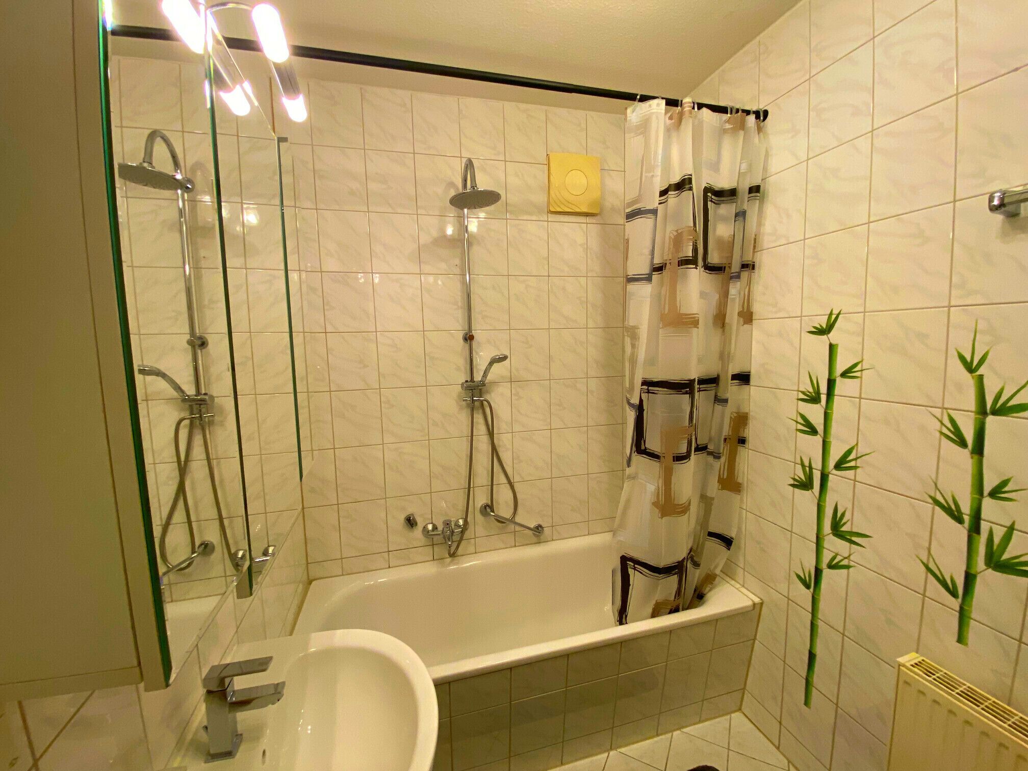 Un bagno con doccia vetrata, vasca e lavandino.