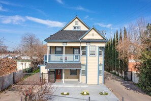 Une maison à deux étages avec un balcon, un garage et une allée.