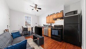 A compact living space with a kitchenette, a dining area, and a sofa with blue cushions. - Cozy 1bdr/1br near downtown (Sacramento)