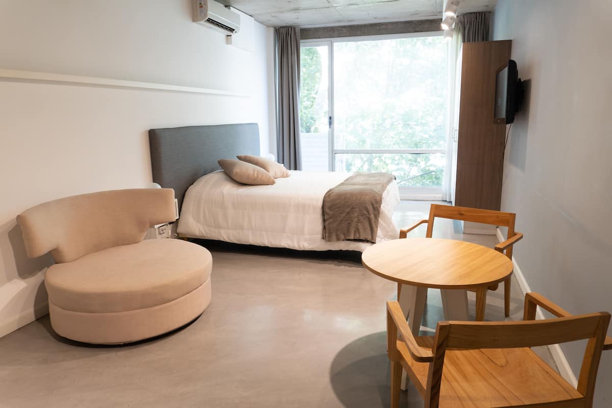 Ein modernes Hotelzimmer mit einem Bett, einem runden Tisch und zwei Stühlen.
