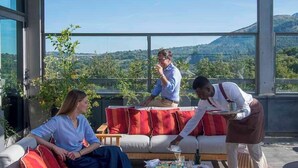 Uma área de estar moderna ao ar livre, com mesa posta para o café da manhã, com vista para uma paisagem deslumbrante.