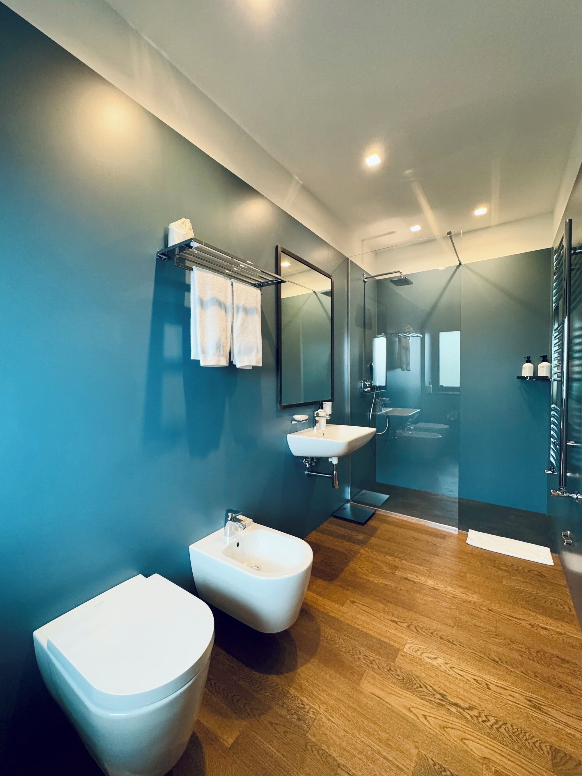 A modern bathroom with a bidet, a sink, and a mirror.