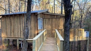 Eine Holzhütte mit einer Holzterrasse und einer Tür.