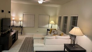 A living room with a white sofa, a TV, and two lamps. - Only 5 minutes from Walt Disney World (Kissimmee)