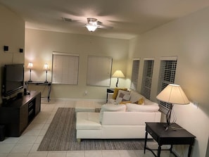 Relax in this stylish living room with a sofa, flat-screen TV, and cozy rug.