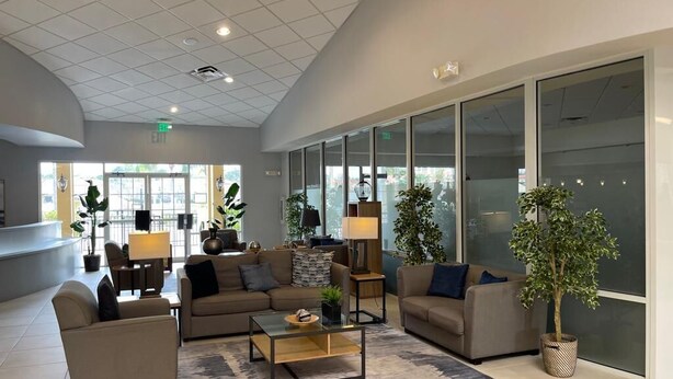 A modern lobby with sofas, a coffee table, and potted plants. - Only 5 minutes from Walt Disney World (Kissimmee)