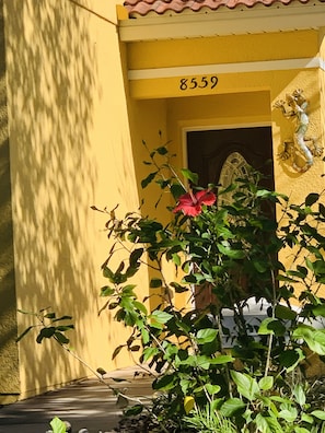 Stunning building with a decorative metal sculpture and lush greenery.