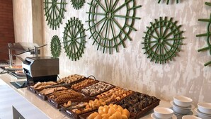 A buffet with various baked goods and a coffee station.